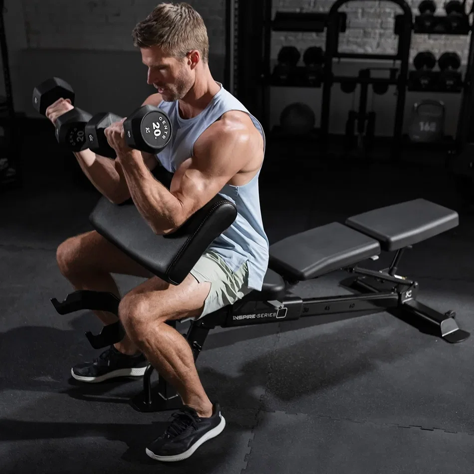 Preacher-style dumbbell curl supported by the Inspire adjustable bench